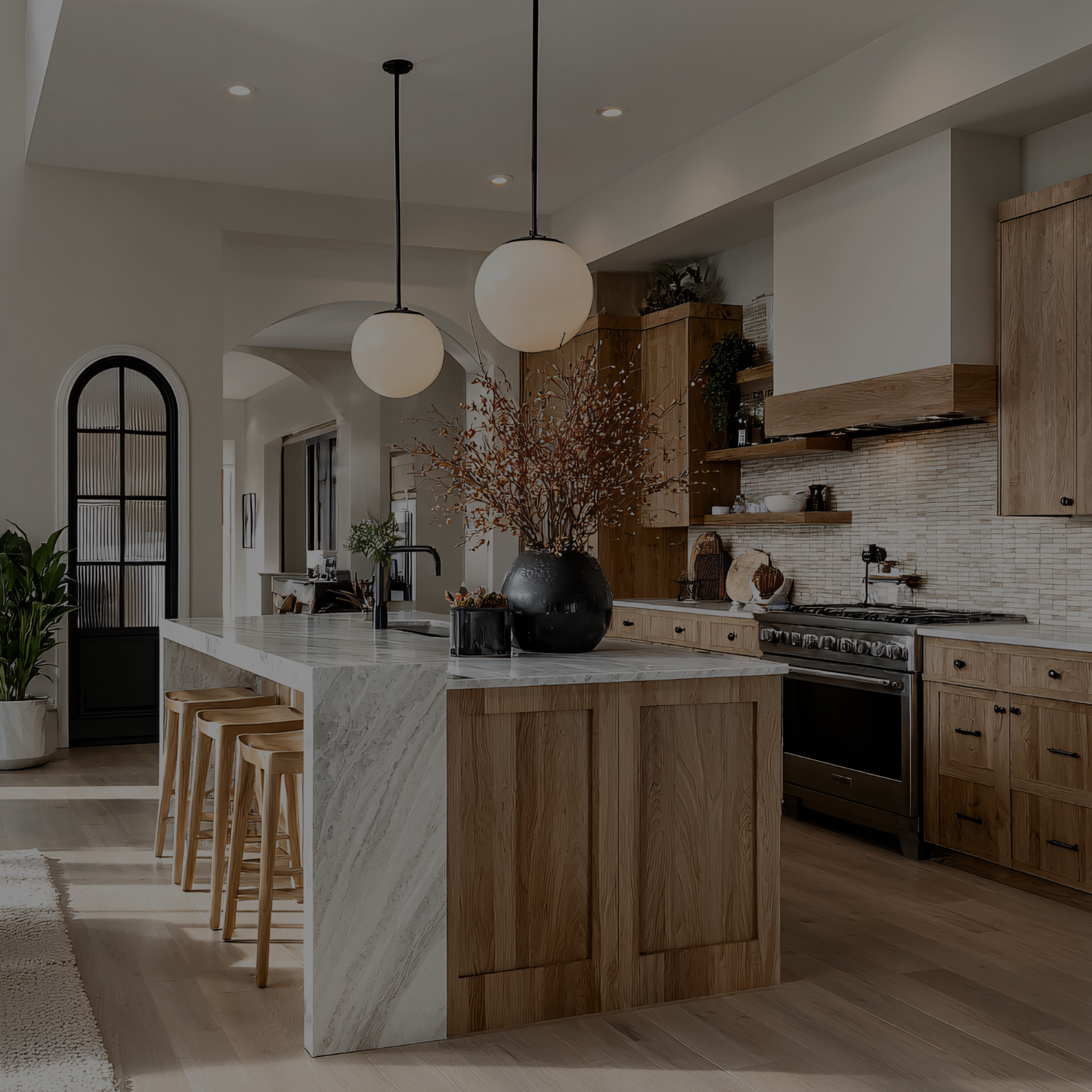 Warm kitchen with wood cabinetry, a marble island, and globe pendant lighting